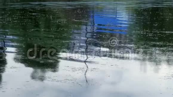 在池塘的水中反映了房屋的屋顶视频的预览图