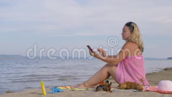 在海滩上拿手机的女人视频的预览图