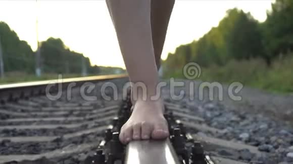 年轻女孩光着脚走在铁路轨道上视频的预览图