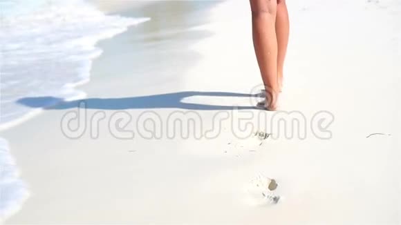 雌性的腿在浅水中沿着白色的海滩奔跑海滩度假和赤脚的概念慢动作视频的预览图