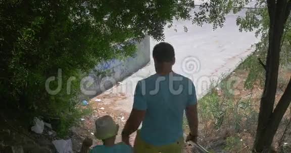 在希腊的佩雷亚市父亲和儿子在公园楼下视频的预览图