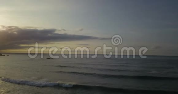 西班牙北部岩石海岸线的空中镜头海滩有海浪日落时有云视频的预览图