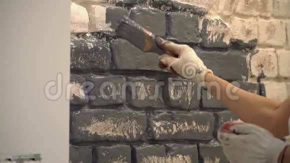 用刷子把一面灰色的砖墙涂在手套上视频的预览图
