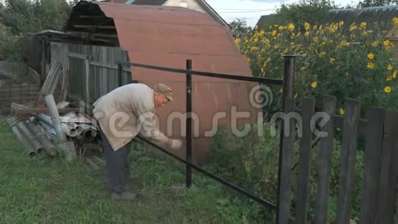 70多岁的老人用黑色油漆铁栅栏视频的预览图
