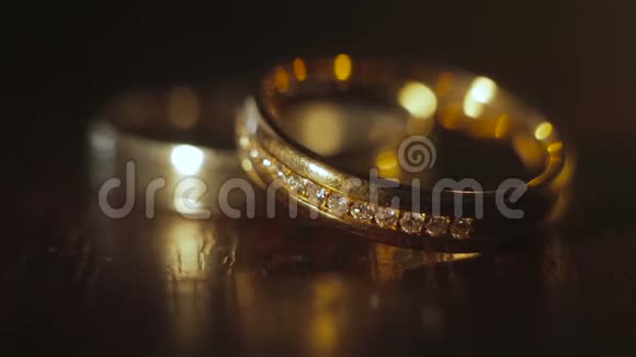 婚礼钻石戒指堆在黑暗的背景上视频的预览图