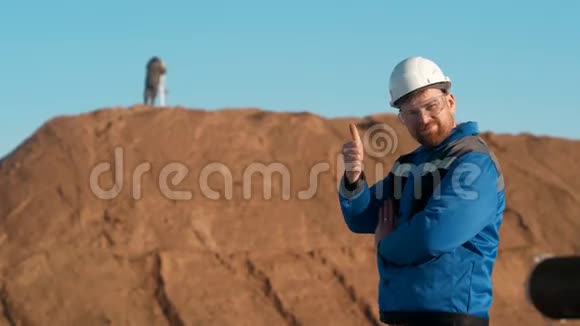 穿着蓝色制服戴着防护眼镜戴着安全帽的红发胡子白种人建筑工人视频的预览图