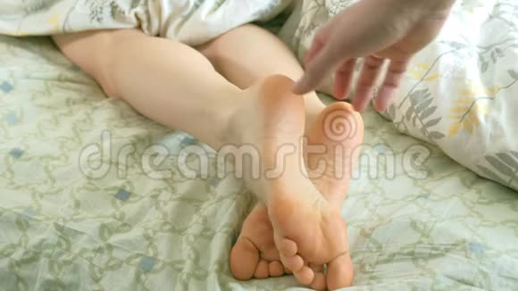 一位慈爱的丈夫叫醒了他的妻子滑稽地挠她的脚视频的预览图