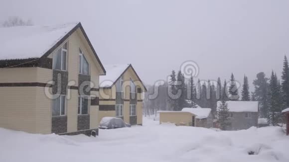 冬天的天气房子在山上的树林里冬天降雪时的自然景观全景视频的预览图