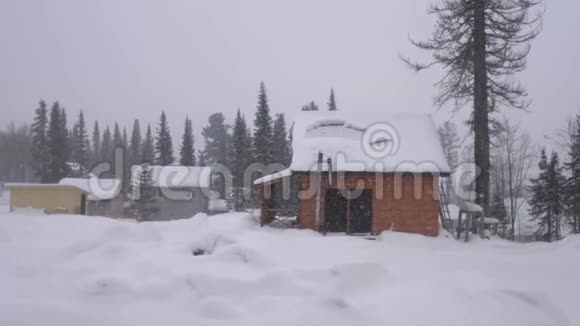冬天的天气房子在山上的树林里冬天降雪时的自然景观全景慢慢慢慢视频的预览图