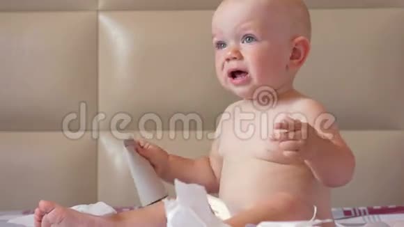 可爱的宝宝坐在床上撕手纸孩子1岁视频的预览图