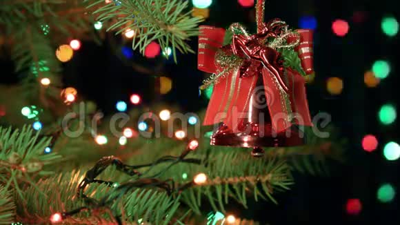 圣诞树上的圣诞钟有模糊的灯光花环童话般的节日气氛视频的预览图