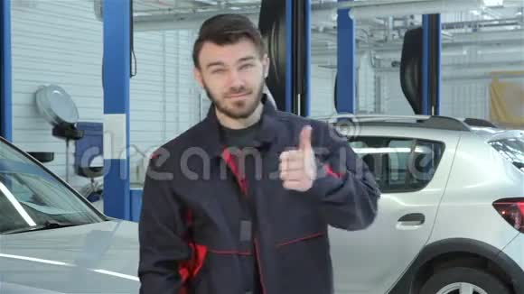 机械师在汽车服务部门展示他的拇指视频的预览图