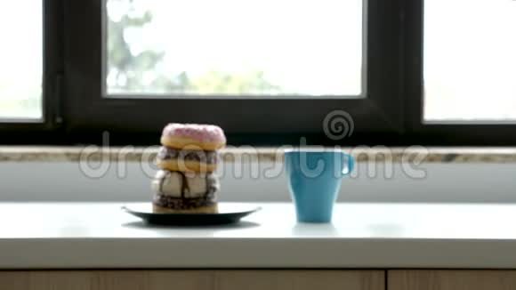 靠近窗户的盘子里放着一杯咖啡和甜甜圈视频的预览图