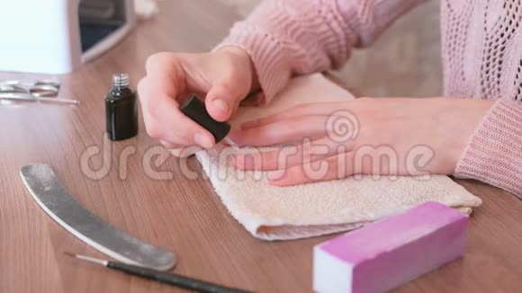 女人在指甲上涂上一层紫胶特写双手视频的预览图