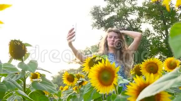 漂亮的女孩模特在向日葵附近自拍高清高清视频的预览图