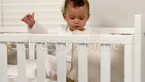 可爱的婴儿坐在婴儿床上视频的预览图