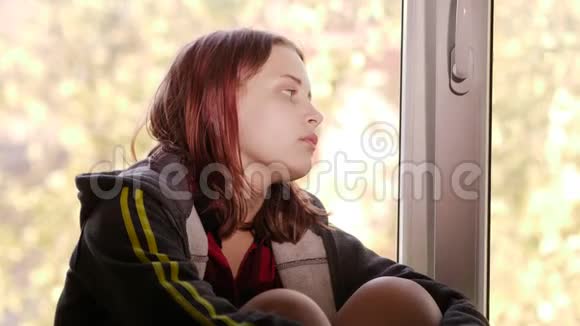 家里很郁闷伤心的女孩靠近窗户视频的预览图