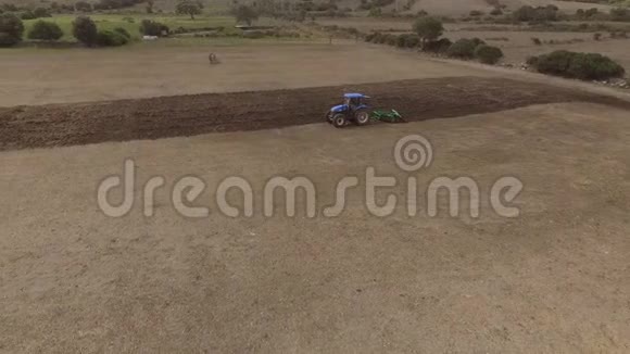 带犁的蓝色拖拉机空中观景无人驾驶飞机视频的预览图