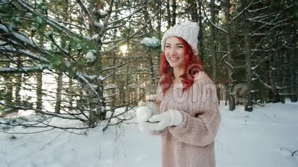 火焰蜡烛红头发的漂亮女孩手里拿着燃烧的蜡烛温暖了冬天森林里的火视频的预览图