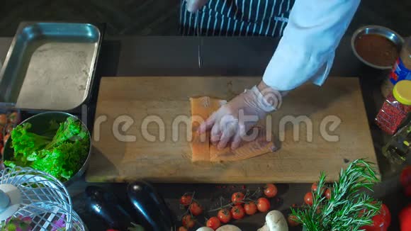 厨师在切菜板上切取鲑鱼鱼片视频的预览图