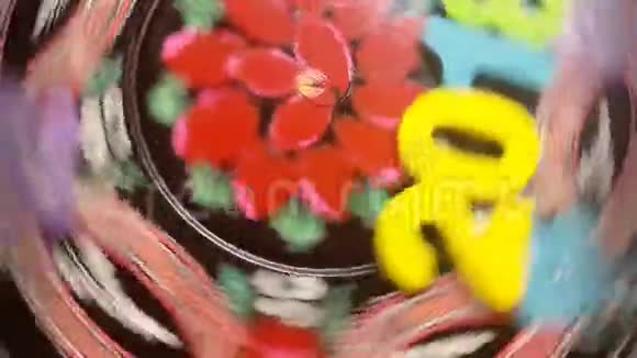 五颜六色的数字2018围绕着一个圆形的木盘与彩绘的花朵装饰视频的预览图