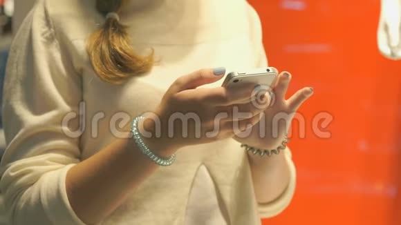 女孩拿着银色智能手机特写镜头视频的预览图