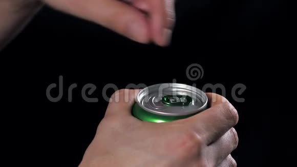 男人把宏手打开铝啤酒罐在黑色背景上隔离视频的预览图