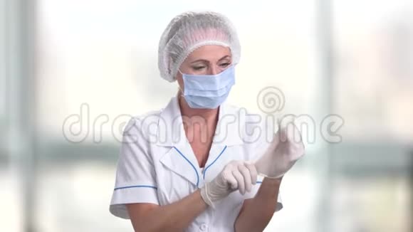 自信的女医生戴上手套视频的预览图