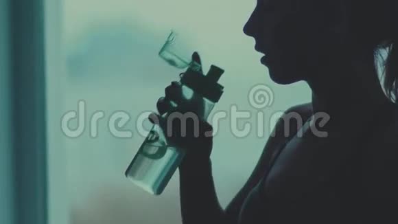 特写一个女人喝水的黑暗轮廓慢动作视频的预览图