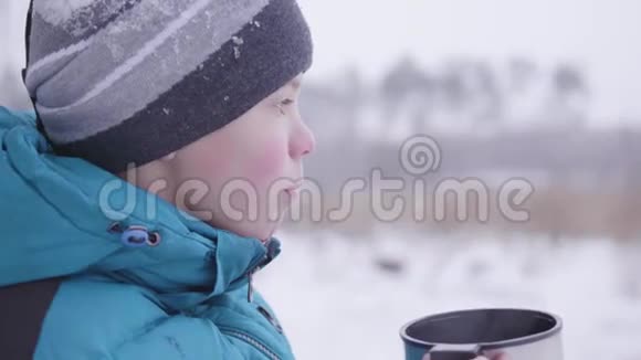 这孩子正在公园里的户外冬天喝茶视频的预览图