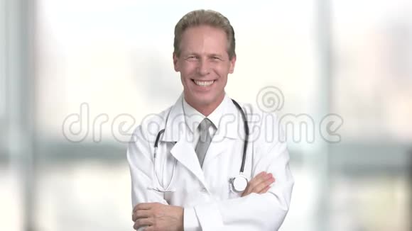 成熟的医生在模糊的背景上笑视频的预览图