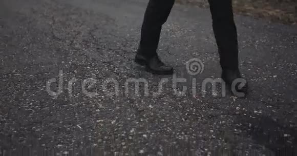 一个穿着黑鞋在路上行走的人俯视动作缓慢4k视频的预览图