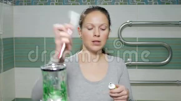一个年轻迷人的女人在酒店房间的浴室里刷牙它会导致刷子上的糊状物视频的预览图