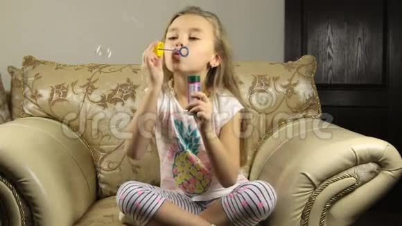 小女孩在家里在明亮的客厅里玩肥皂泡视频的预览图