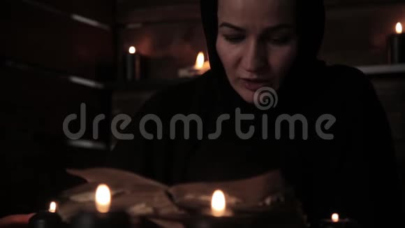 修女正在读旧书突出了蜡烛的火焰基督教观念视频的预览图
