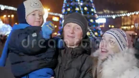 幸福的家庭在城镇广场庆祝新年每个人都看着相机微笑背景是视频的预览图