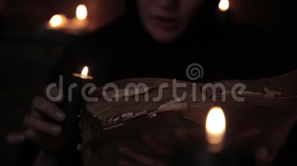 修女正在读旧书突出了蜡烛的火焰基督教观念视频的预览图
