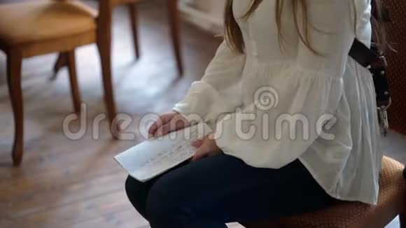 年轻女子坐在椅子上拿着文件视频的预览图