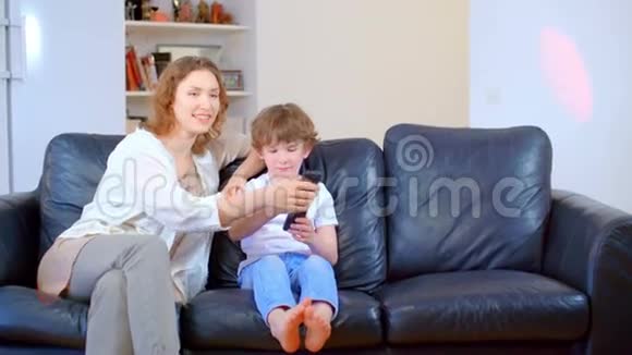 幸福的儿子父亲和母亲之间的家庭关系他们看电视品尝披萨视频的预览图