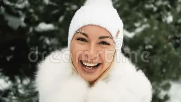 戴着白色帽子的快乐女人戴着绿色松树的毛茸茸的手套视频的预览图