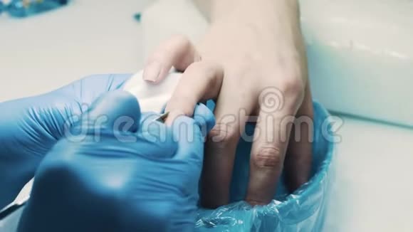 医生在沙龙使用手术刀切断病人手指的角质层视频的预览图