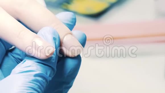 美甲师用透明指甲油涂在美容院的拇指指甲上视频的预览图