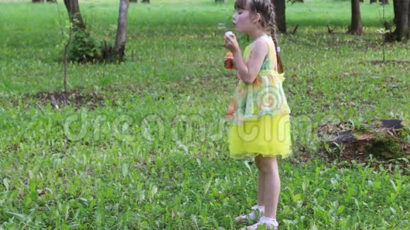 夏天漂亮的小女孩在公园里吹泡泡视频的预览图