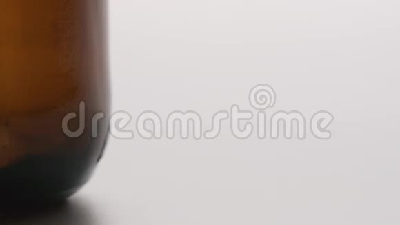 慢镜头瓶盖落在一个棕色的大瓶子附近视频的预览图