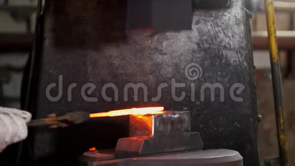 自动机械锤击铁匠在铁砧上锻造红铁长焦视频的预览图