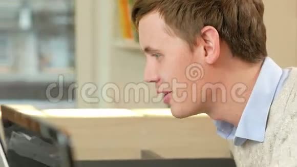 那个人盯着办公室里的笔记本电脑屏幕他笑了笑因为他看到了什么特写视频的预览图