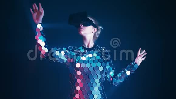漂亮的金发美女戴着未来镜套装玩虚拟现实眼镜游戏视频的预览图