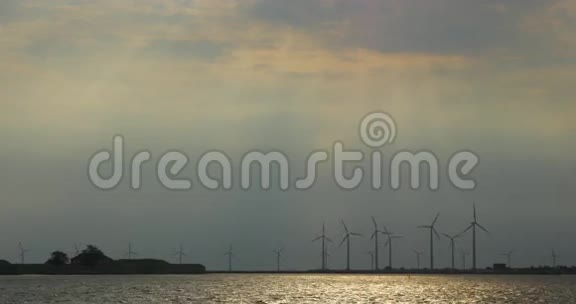日落时河岸上的风车视频的预览图