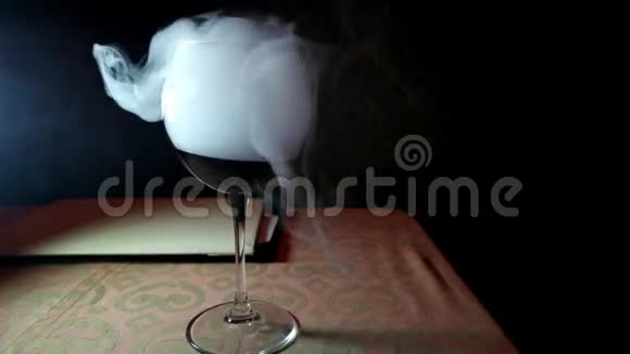 干冰的效果在酒吧的玻璃上翻腾在罐子里吹出白色的浓烟喝着一杯红酒视频的预览图