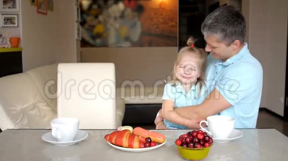 快乐的父亲和女儿一起在厨房吃早餐视频的预览图